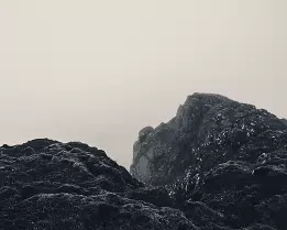 Mist Veil Dark rocky peaks fading into mist in the Faroe Islands.