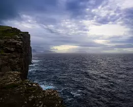 Distant Light Cliffside at Trælanípa overlooking the Atlantic Ocean under soft light in the Faroe Islands.
