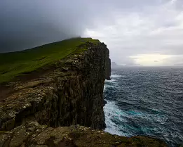 Mist Rise Ocean cliffs at Trælanípa disappearing into low mist in the Faroe Islands.