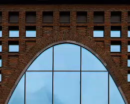 Arched Façade Brick façade with arched glass opening and regular square windows at Helsinki University’s Kaisa House library building.