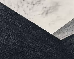 Stark Geometry Angled dark brick facade meets an overcast sky in Oslo.