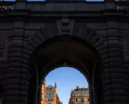 Stone Gateway The granite arch of Sweden’s Parliament (Riksdagshuset) frames a sunlit city street beyond.