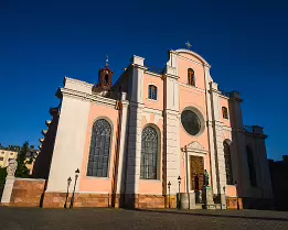 Storkyrkan Facade Stockholm Cathedral (Storkyrkan) glows peach and white in low morning light against a cloudless sky.